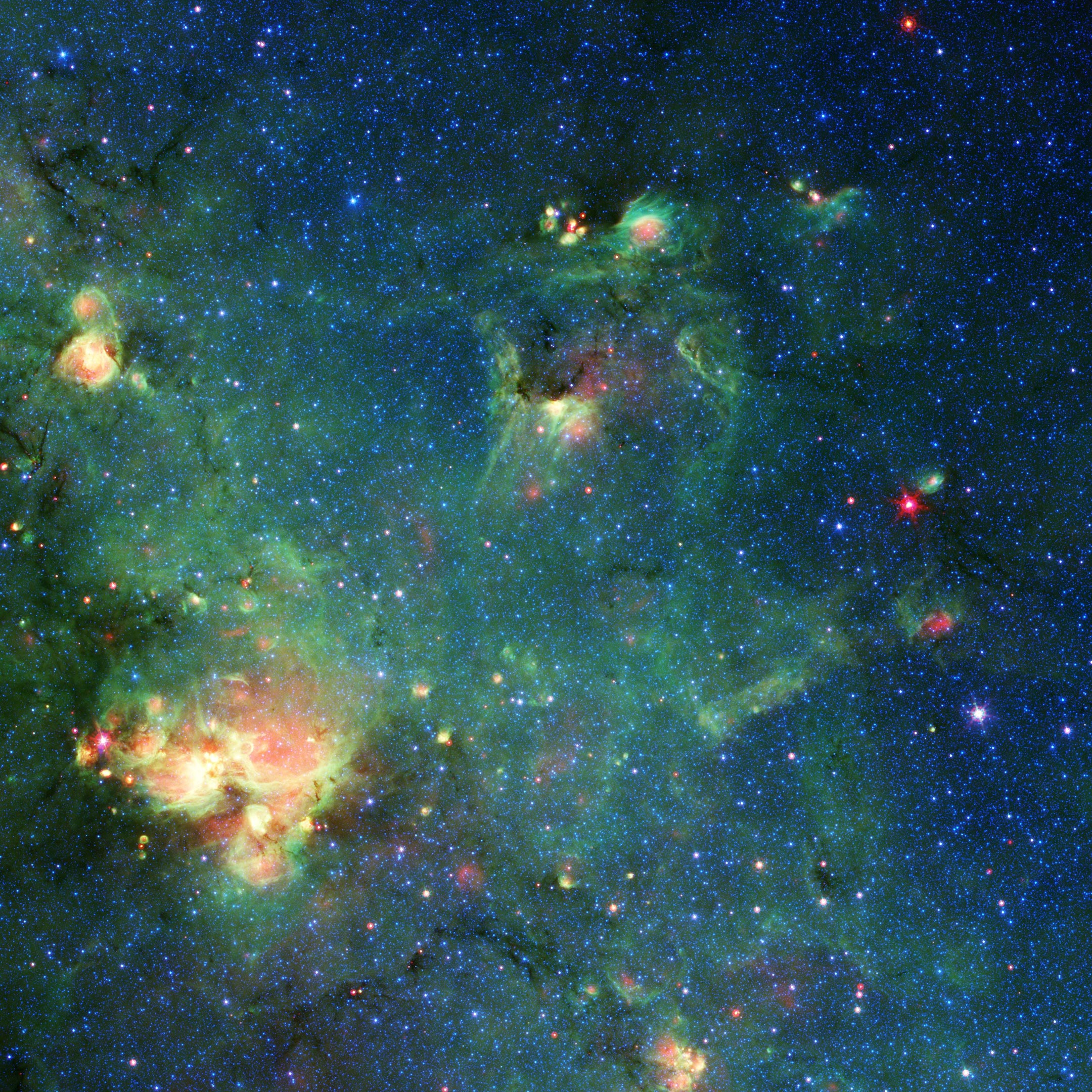 Telescopio espacial Spitzer de la NASA tomó imágenes de esta nube de gas y polvo. Los colores representan diferentes longitudes de onda de luz infrarroja y pueden revelar características tales como lugares donde la radiación de las estrellas había calentado el material circundante. Cualquier parecido con Godzilla es puramente imaginario. Crédito: NASA/JPL-Caltech